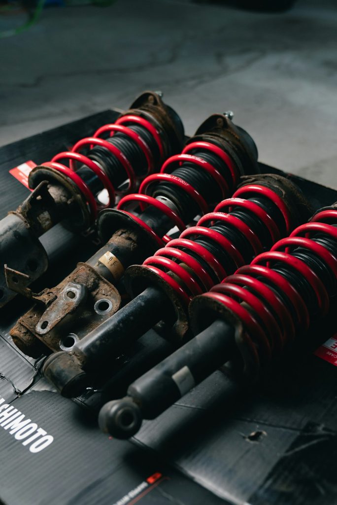 four-red-coilover-suspension-assemblies-on-a-black-surface-0lrw9vqbtgo